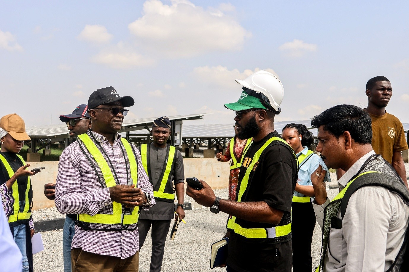 From left: Engr. Timothy Shekarau, Senior Technical Design Specialist for the DARES Project, explains the technical standards and operational efficiency of the 3.3MW hybrid solar plant to developers during site inspection, supporting quality assurance for interconnected mini-grid deployment.